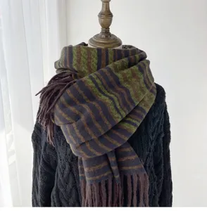Detailed view of a stylish women knitted winter scarf with colorful stripes and cozy tassel hem.