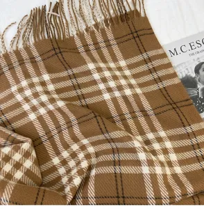 Detail shot of winter plaid scarf, soft cashmere-feel fabric with stylish fringe and classic pattern.