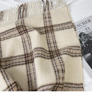 Close-up of cozy winter plaid scarf with fringe detail, soft and warm texture for daily wear.