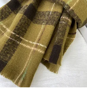 Detail view of winter plaid scarf, warm cozy thick long shawl, retro olive green check design.