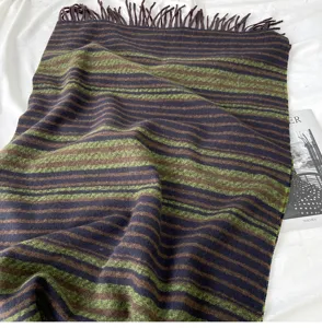 Detailed view of a cozy autumn and winter striped fringed scarf in brown and green tones.