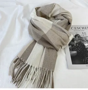 Detailed shot of a cozy brown and white plaid winter scarf with elegant fringe ends.