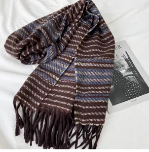 Detail view of brown and blue striped winter scarf with soft texture and stylish tassel fringe.