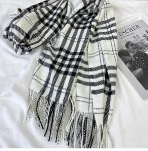 Black and white plaid scarf detail shot showing classic checkered pattern and fringe.