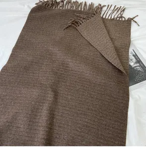 Detailed close-up view of the soft brown cashmere-feel winter scarf showing texture and tassels.