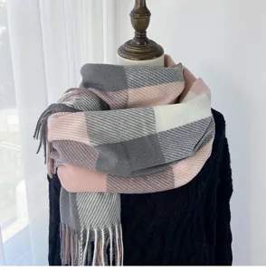 Detailed view of the thick winter plaid scarf with cozy pink, grey, and white color blocks.