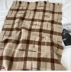 Detailed view of the vintage brown plaid scarf, thick warm material, cozy winter accessory.