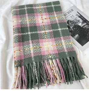 Detail view of a cozy pink and green plaid fringed scarf, soft cashmere-feel winter neck wrap.