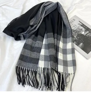 Detail view of women's black grey plaid cashmere feel scarf with soft fringes and warm design.