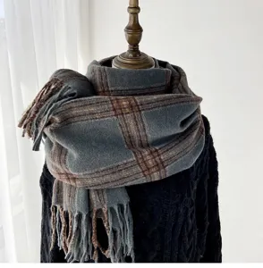 Detail view of the cozy grey and brown plaid scarf featuring elegant fringe tassels for winter.