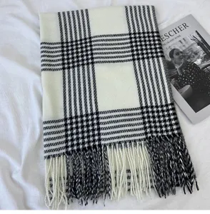 Detailaufnahme des klassischen schwarz-weißen Karoschals für den Winter mit Fransen.