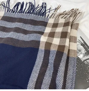 Detailed close-up shot of a cozy women's plaid winter scarf featuring elegant fringe trim.