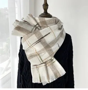 Cozy winter plaid scarf detail, soft woolen material with elegant fringe design, warm beige tone.