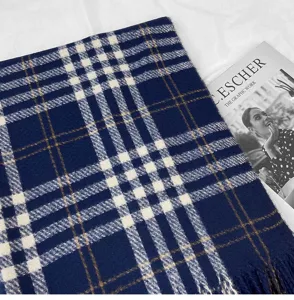 Close-up detail of classic navy blue plaid imitation cashmere scarf with elegant fringes.
