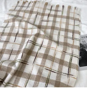Close-up shot of the soft cozy plaid scarf, showing rich texture and vintage pattern details.