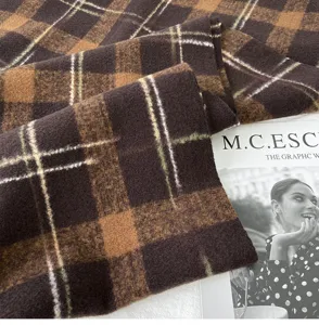 Brown plaid scarf fabric detail showing soft winter woolen texture and cozy vintage warmth.