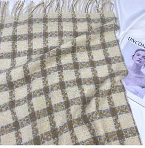 Close-up of cozy winter plaid scarf with fringe, soft cashmere-feel fabric texture detail.