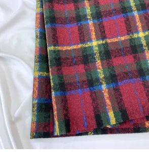 Close-up detail of a classic vintage red and green plaid winter scarf fabric texture.