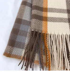 Detailed shot of soft winter imitation cashmere plaid scarf with elegant fringe trim.