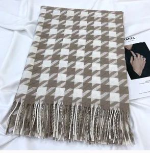 Detailed view of brown white houndstooth tassel scarf texture and soft cozy fabric.