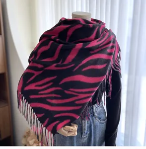 Detailed view of the pink and black zebra print cashmere-feel winter scarf with chic fringe edges.