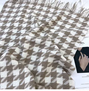 Detailed shot of a soft brown white houndstooth tassel scarf, cozy winter imitation cashmere.