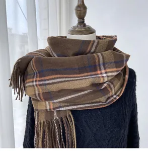 Detailed view of women winter brown plaid scarf with cozy cashmere feel and stylish tassel trim.