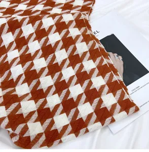 Brown and white houndstooth scarf with cozy soft fabric and fringe tassel design detail view.
