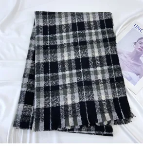 Detailed view of black and grey plaid winter scarf, soft cashmere-like material shawl.
