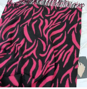 Close-up detail view of pink and black zebra print imitation cashmere scarf with tassels.