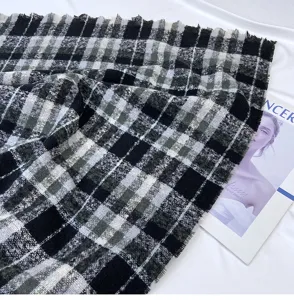 Black and grey plaid cashmere feel winter scarf detail view showing soft fabric texture and fringe.
