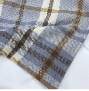 Detailed close-up of winter plaid cashmere-feel scarf texture, classic blue brown pattern.