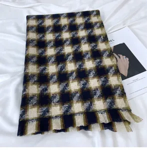 Vue détaillée d'écharpe d'hiver à motif pied-de-poule doux avec franges et tissu chaud.