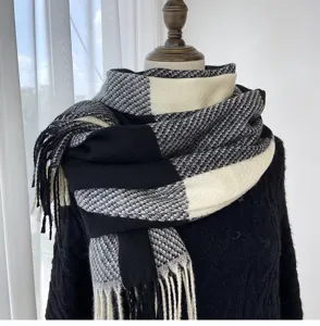 Close-up detail of a classic black and white plaid tassel scarf, soft winter warmth.