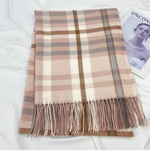Detailed view of women's pink and brown plaid tassel scarf, soft winter accessory.