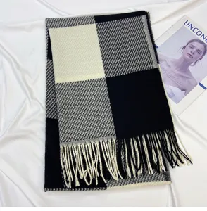 Detailed view of the classic black and white plaid scarf featuring soft tassel edges.