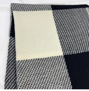 Detailed close-up view of a fashionable black and white color-block knitted plaid scarf.