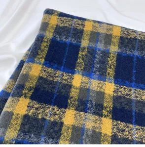 Detailed shot of winter plaid cashmere-feel scarf in blue, yellow, and grey check.