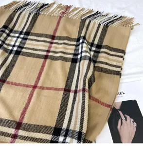 Detailed view of women's classic plaid cashmere-feel winter scarf featuring elegant fringe trim.