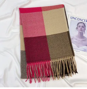Detailed view of women's cozy winter color block plaid scarf with fringe imitation cashmere.