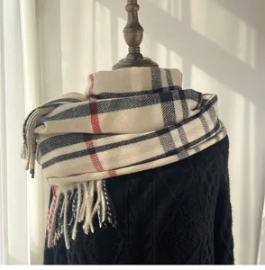 Close-up detail of the classic plaid scarf with fringe, soft cashmere-feel fabric texture display.