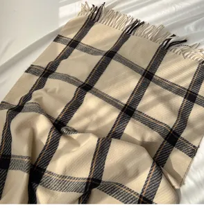 Close-up detail of the classic plaid winter scarf with fringe, soft texture and warm design.