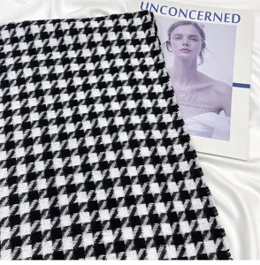 Black and white houndstooth scarf fabric detail, cozy texture with fringe edge design.