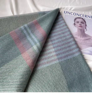 Detailed close-up of a soft cashmere-feel plaid scarf with elegant twill texture.