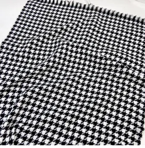 Close up shot of the classic black white houndstooth winter warm cashmere scarf texture detail.
