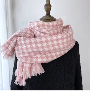 Detailed view of the pink and white houndstooth scarf with delicate tassels, warm winter wear.