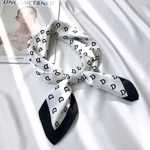 Chic white silk scarf with black letter print and contrast black hem for elegant women styling.