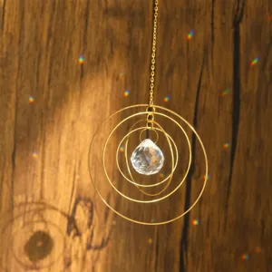 Detailed view of crystal suncatcher with golden concentric rings casting colorful rainbow light.