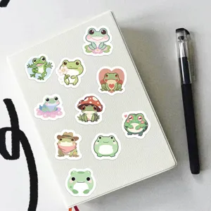 Cute green frog stickers detail view, aesthetic stationery items for journaling and DIY crafts.