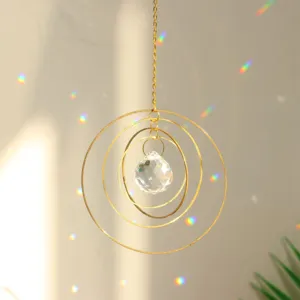 Crystal suncatcher detail shot featuring concentric gold rings and sparkling rainbow light.